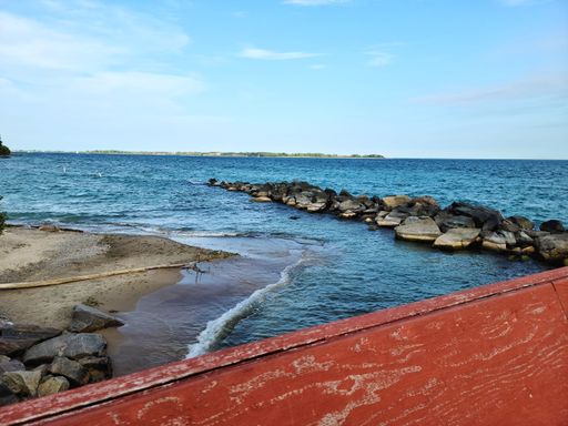 A beautiful lake landscape of a rocky beach on the Toronto Islands, Canada, on a bright day