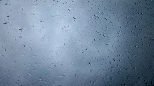 A closeup shot of raindrops on a glass - perfect for a rainy background
