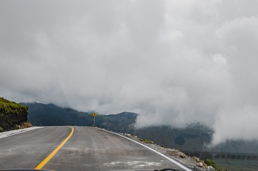A beautiful shot of a road with foggy hills in the background