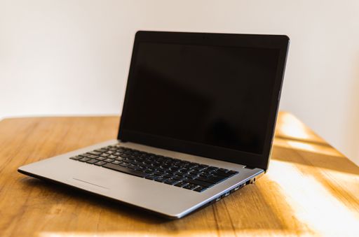 A closeup shot of a laptop on a wooden table