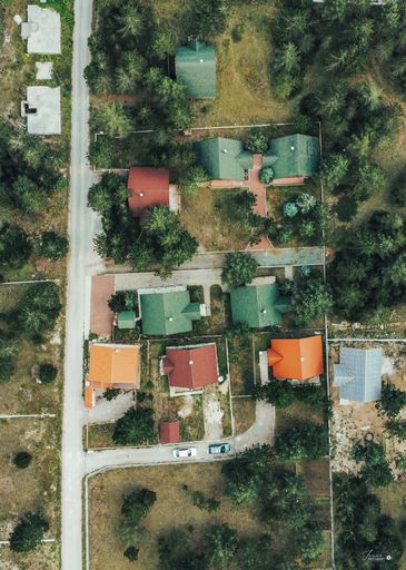 A vertical aerial of houses with colorful roofs