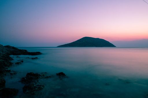 A mesmerizing pink and purple sunset over calm sea waters
