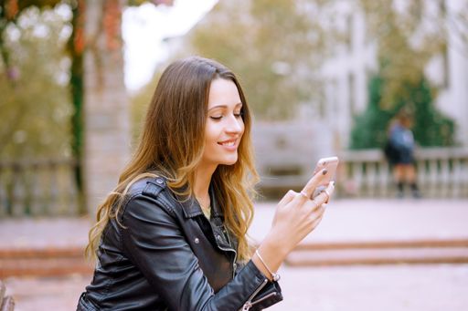 A cheerful blonde female happily looking at her phone after getting a funny message