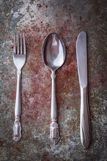 A high angle shot of a fork, knife, and a spoon on a table