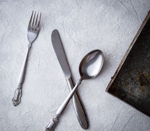 A high angle shot of a fork, knife, and a spoon on a table