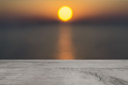 A wooden surface on background of a blurred sunset on a sea