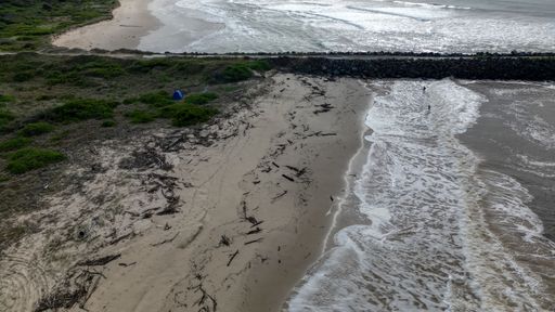 An aerial view of soft waves with foam on a beach in Port Macquarie, NSW, Australia