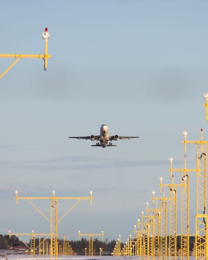 A vertical shot of an airplane taking off from the runway during the evening