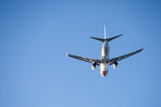 A low-angle shot of an airplane taking off with the blue clear sky in the background