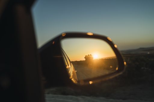 A selective focus shot of beautiful sunset seen through the car side mirror