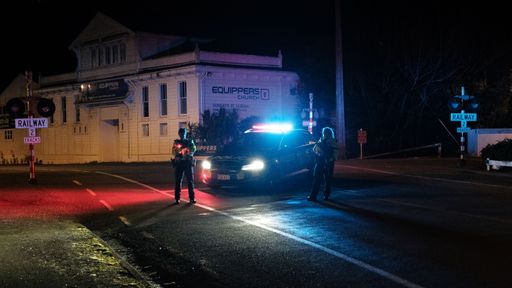 A nite view of New Zealand Police hold a road block during a raid.