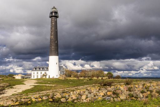 The image shows a lighthouse on  the Sorve Peninsula on the  island of Saaremaa in Estonia under a cloudy sky