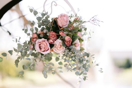 A closeup of a bouquet of beautiful pink and white roses on a blurred background at a wedding