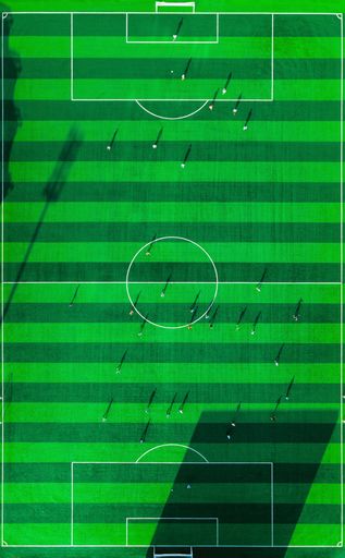An aerial view of sport stadium of football with football players in sunny day