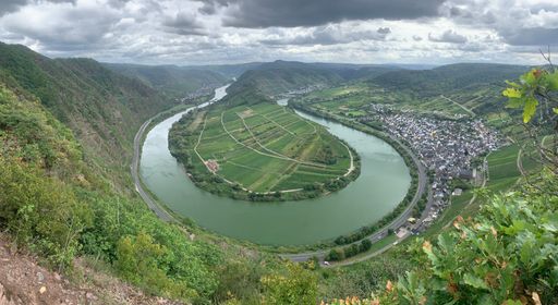 Mesmerizing view of beautiful Mosel river surrounded with greenery and city of Bernkastel-Kues in Germany