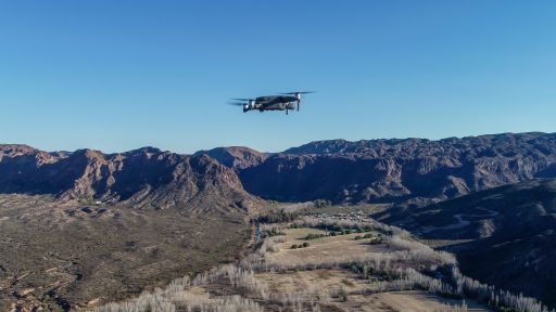 An aerial shot of a drone flying over mountains