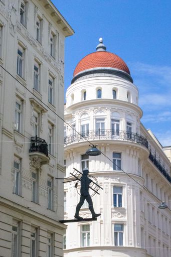 A vertical shot of a statue on a building in the wonderful city of Vienna, Austria on a summer day