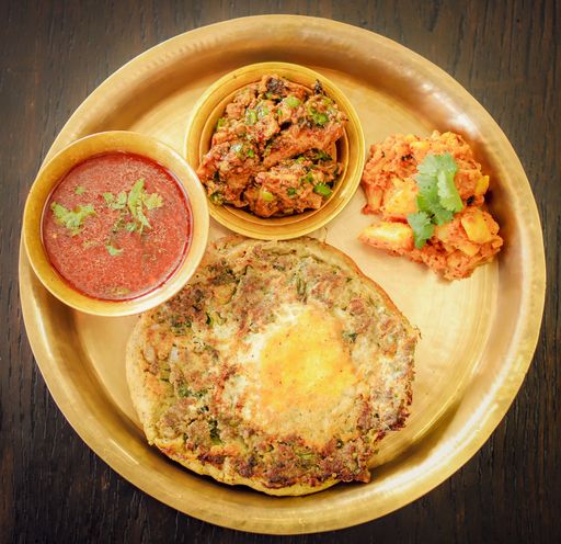 A high angle closeup shot of Newar food in a tray isolated on a wooden surface - great for an article about traditional foods
