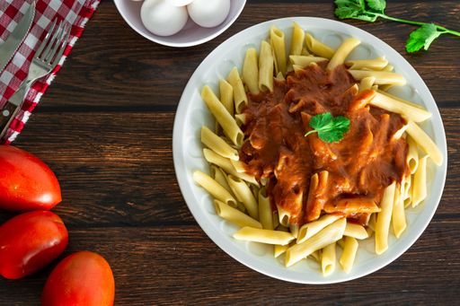 typical italian pasta on wooden background with tomato sauce