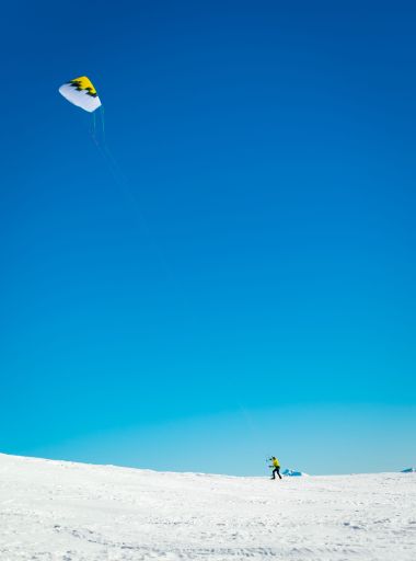 A vertical shot of a skier on the snowy slope of a mountain in Trentino, Italy