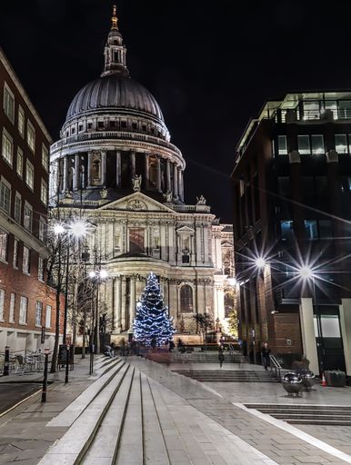 A vertical shot of a Christmas tree in the middle of the city during evening time