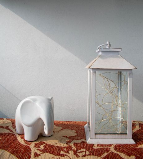 A closeup shot of a decorative white lamp and a simple elephant figurine for interior design