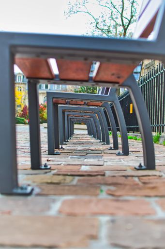 A vertical low-angle shot of the metallic feet of benches in a park