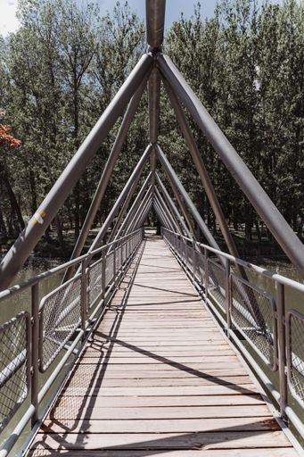 A vertical shot of the Duero bridge over the river with a blue cloudy sky in the background, Soria, Spain