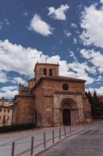 A vertical shot of the San Juan de Rabanera church in front of a blue cloudy sky, Soria, Spain