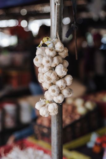 A vertical shot of a garlic bundle hang in a market