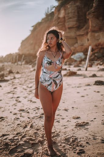 A vertical shot of a young lady posing on the beach