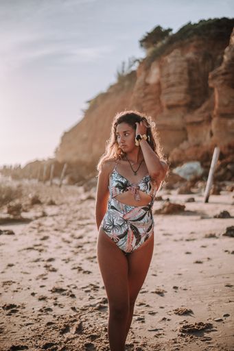 A vertical shot of a young lady posing on the beach