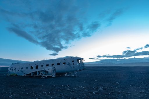 A beautiful shot of the remainings of an aircraft in an abandoned area under the cloudy sky