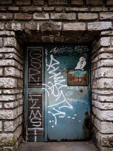 A vertical shot of graffiti on blue metal door