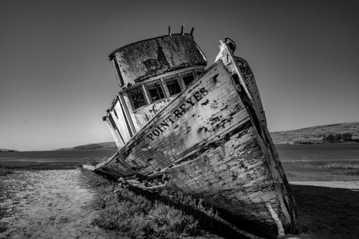 Point Reyes Boat in Inverness California by Point Reyes Station. Broken, rotting, and sitting on the shore.