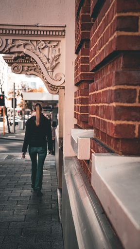 A vertical shot of a young female walking down the street