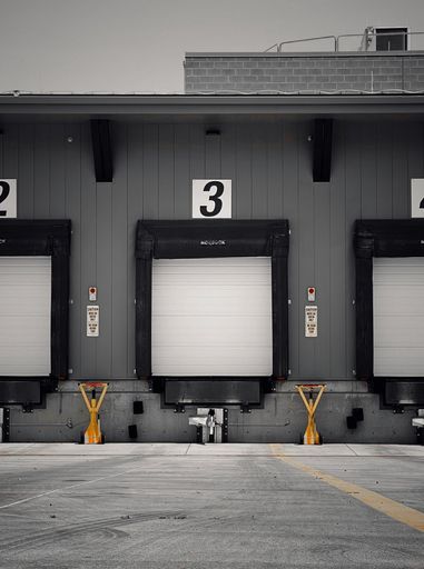 A vertical shot of large windows with black circles closed with white curtains