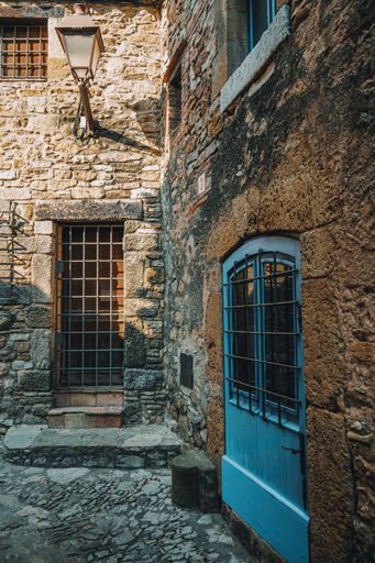 A vertical closeup shot of an old town streets and a beautiful building with blue door