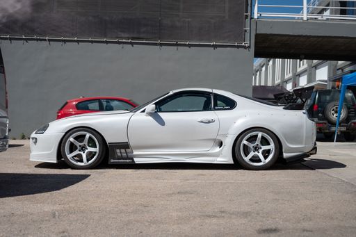 A side view of a parked 4th generation Japanese Toyota Supra sports car