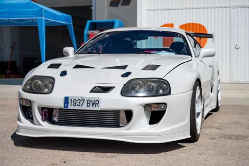A front view of a parked white 4th generation Japanese Toyota Supra sports car