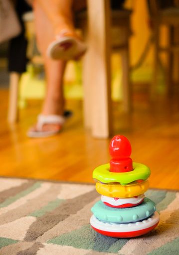 A vertical shot of a colorful baby toy on a carpet on the floor
