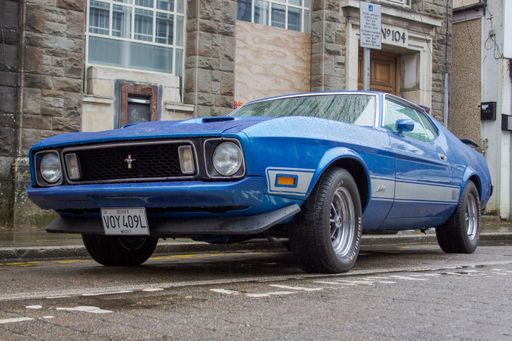 A Ford Mustang Mach 1 classic muscle car on a rainy day.