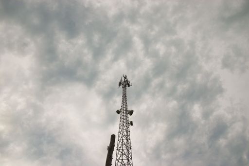 A low angle shot of a cell tower against a stormy sky in Kentucky