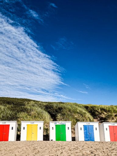 Colorful beach huts on a sunny say in Devon, the UK
