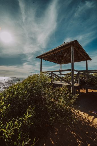 A vertical shot of a small wooden cottage near the ocean