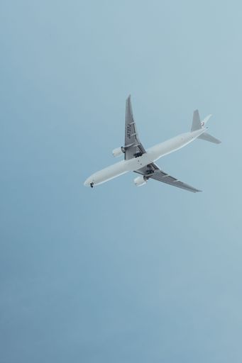 A vertical shot of an airplane soaring above Tokyo