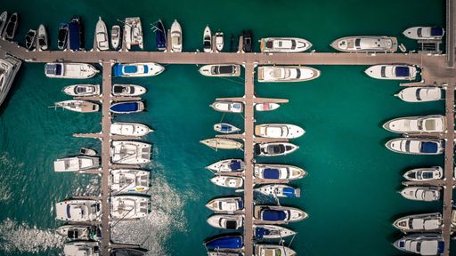A top view of a busy harbor with many parked boats and yachts