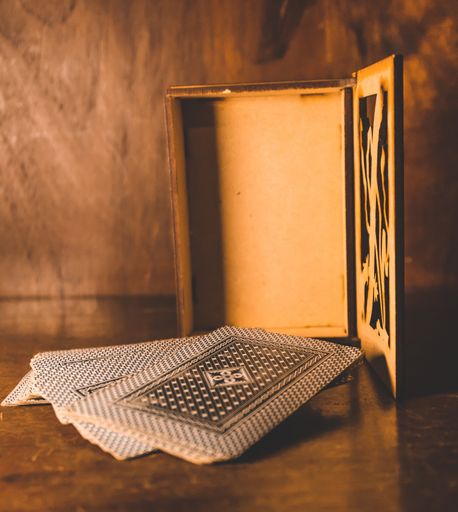 A closeup of playing cards on the table with a wooden box