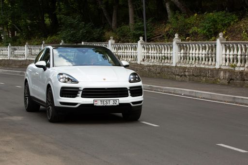 A white Porsche cayenne on a road during a presentation in Armenia