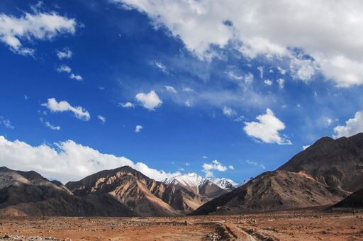 A beautiful landscape with big mountains with rocky peaks against the blue cloudy sky